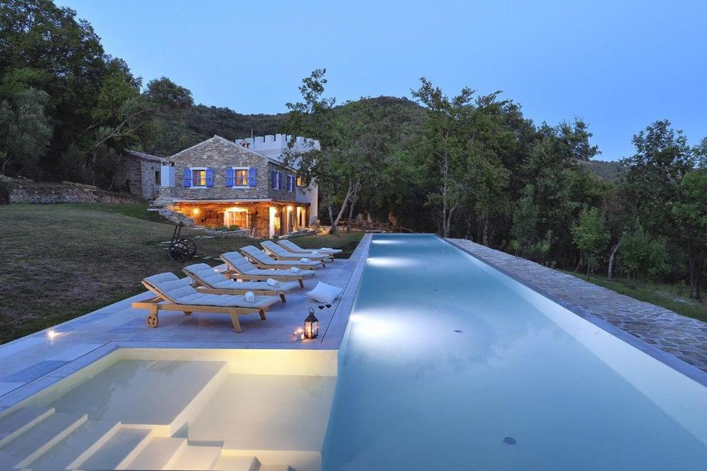 莫托文Villa Torrecorta的一个带躺椅的游泳池以及一座房子