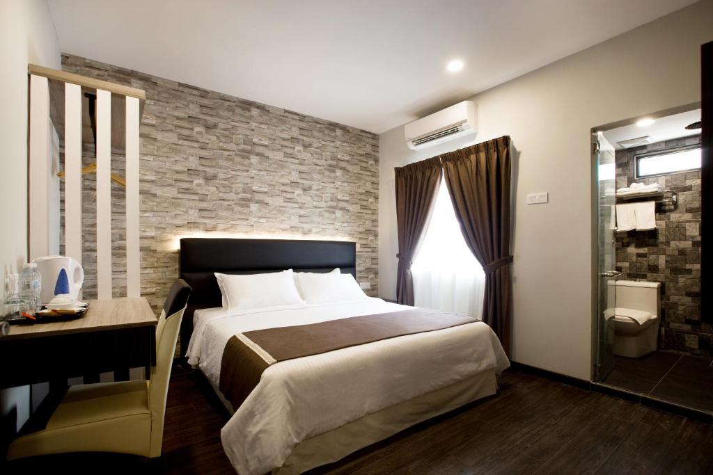 乔治市格尼酒店的一间卧室设有一张大床和砖墙