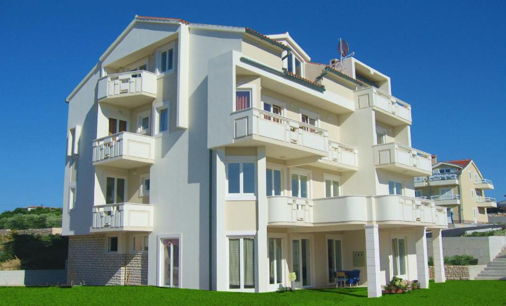 诺瓦利娅Apartments Mirage的白色的建筑,旁边设有阳台