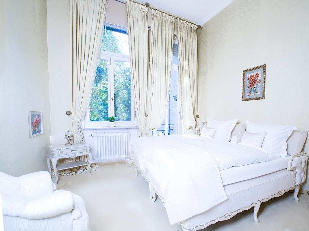 巴登-巴登Royal Apartment City Center Baden-Baden的白色的卧室设有一张大床和一个窗户