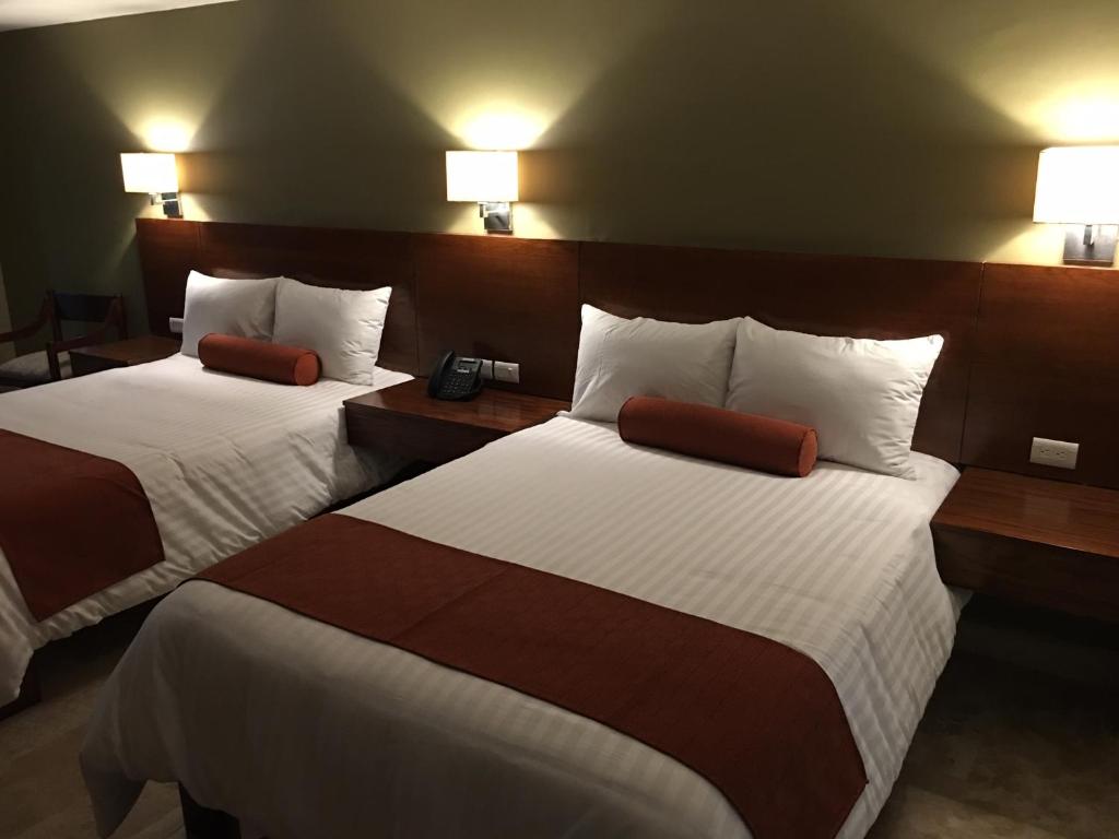 贾拉普Hotel Posada del Virrey的酒店客房设有两张床和两盏灯。