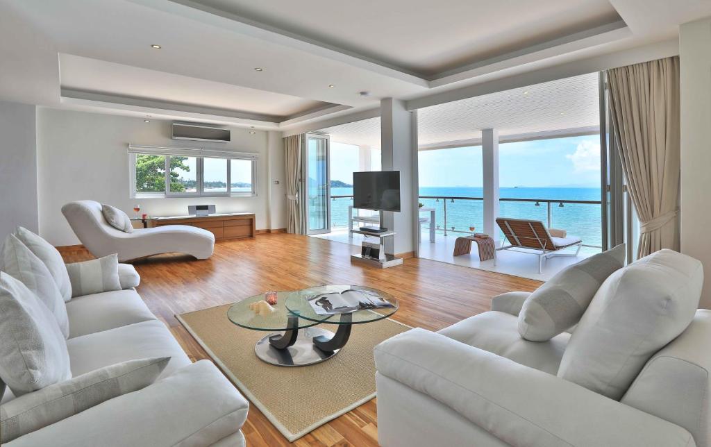 波普托奥修豪华公寓的客厅配有白色家具,享有海景。