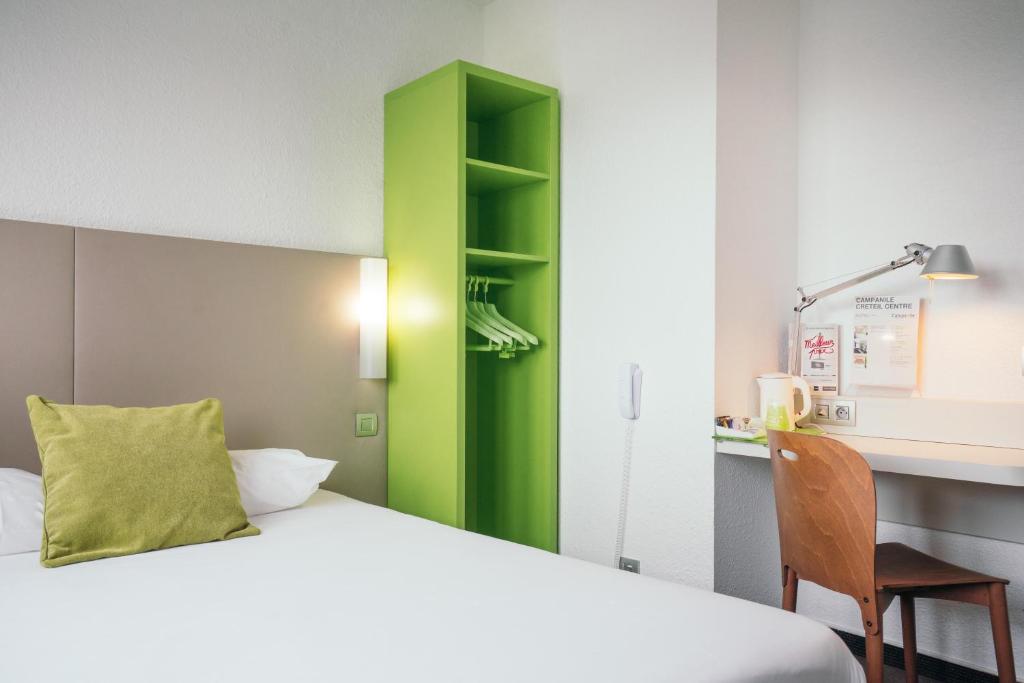 克雷泰伊钟楼克莱特伊中央酒店的客房设有床、书桌和绿色橱柜。