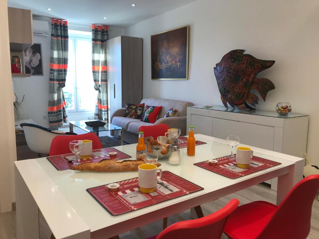 尼斯坎迪尔公寓的客厅配有桌子和红色椅子