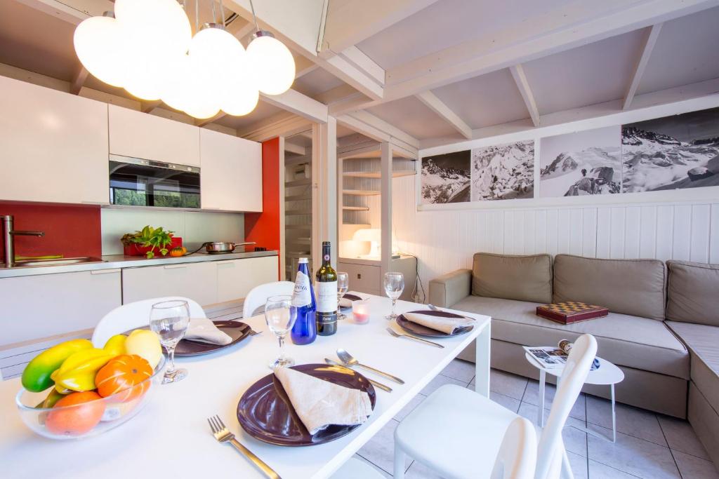 夏蒙尼-勃朗峰Résidence Grand Roc - Campanules 303 - Happy Rentals的厨房以及带白色桌椅的起居室。