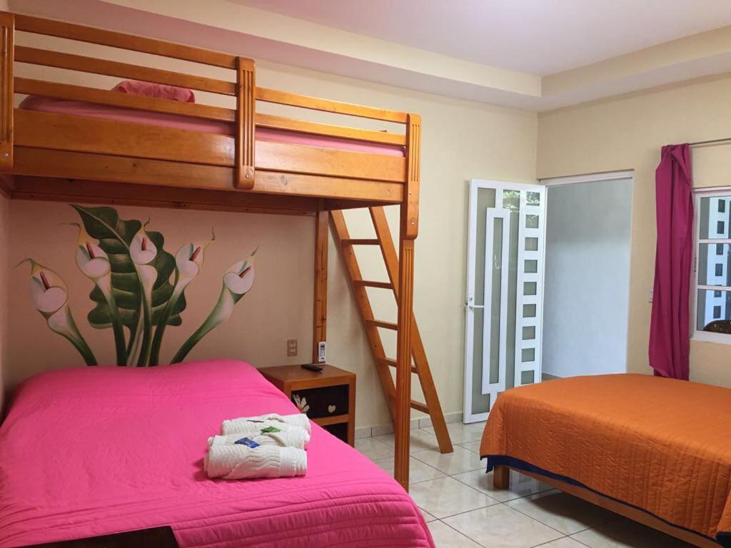 希利特拉Hotel Jovita的一间卧室配有一张双层床和粉红色床罩