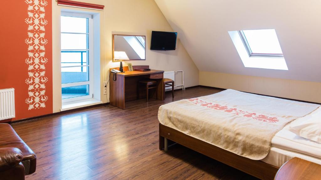 彼得罗扎沃茨克奥涅加城堡酒店的一间卧室配有一张床、一张书桌和一个窗户。