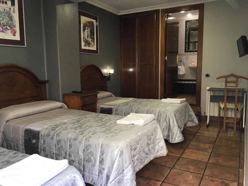 洛格罗尼奥Pensión La Redonda的酒店客房设有三张床和一张桌子