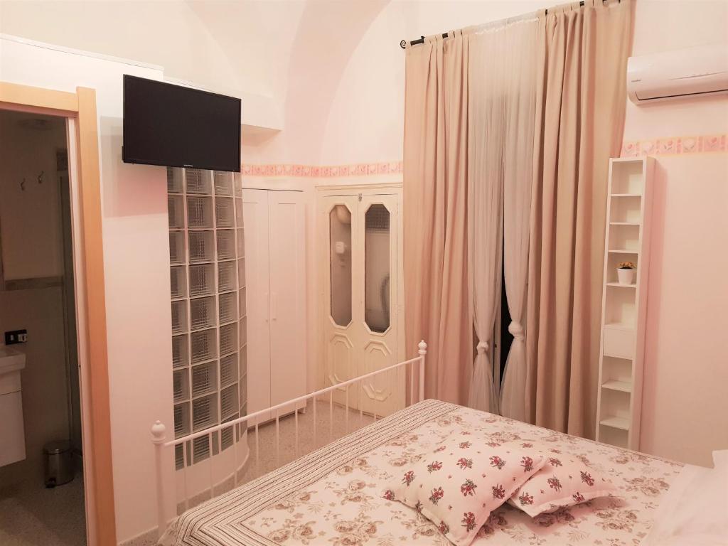 阿尔塔穆拉Gli Oleandri的卧室配有一张床,墙上配有电视。