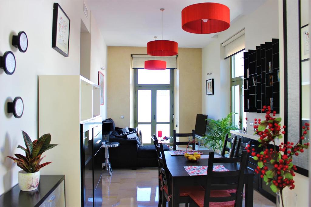 塞维利亚Luxury Apartment Sierpes的办公室,配有桌椅和红灯