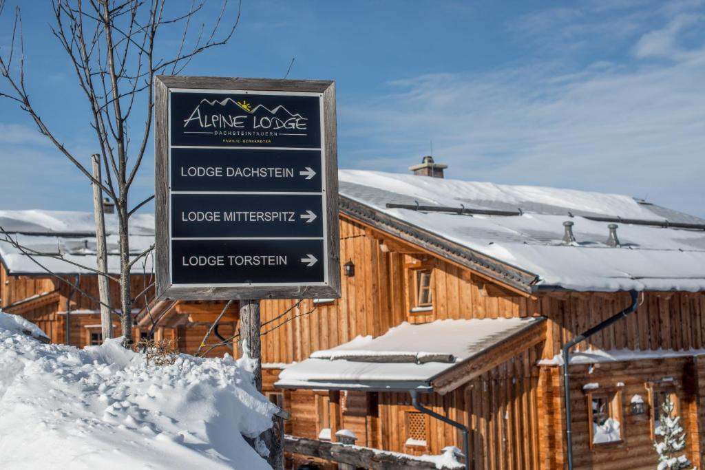 斯拉德明阿尔卑斯-洛奇酒店的雪上小屋前面的标志