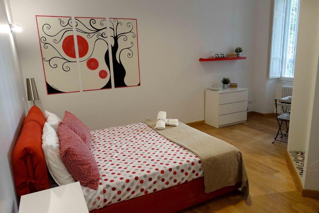 罗马Affittacamere ROMA FLAMINIO的卧室配有一张床,墙上挂有绘画作品