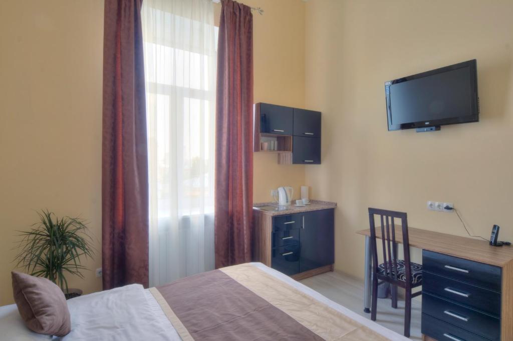 基辅最佳季节公寓酒店的一间卧室配有一张床、一张书桌和一台电视