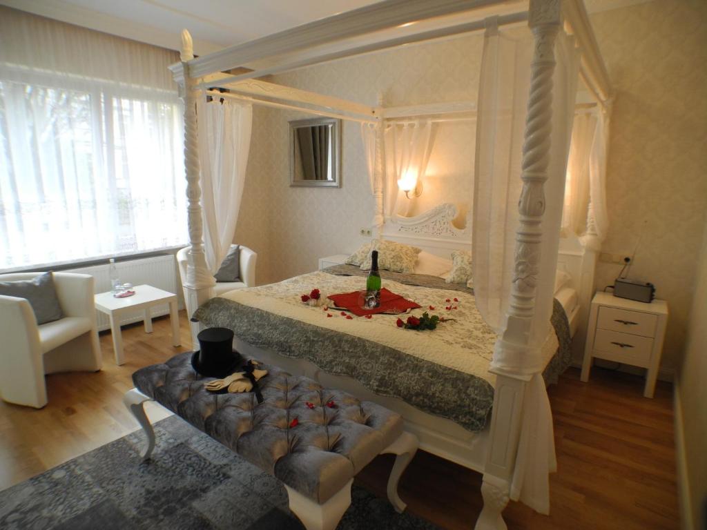 巴特哈尔茨堡Stadtparkhotel Alexandra的一间卧室配有四柱床和沙发