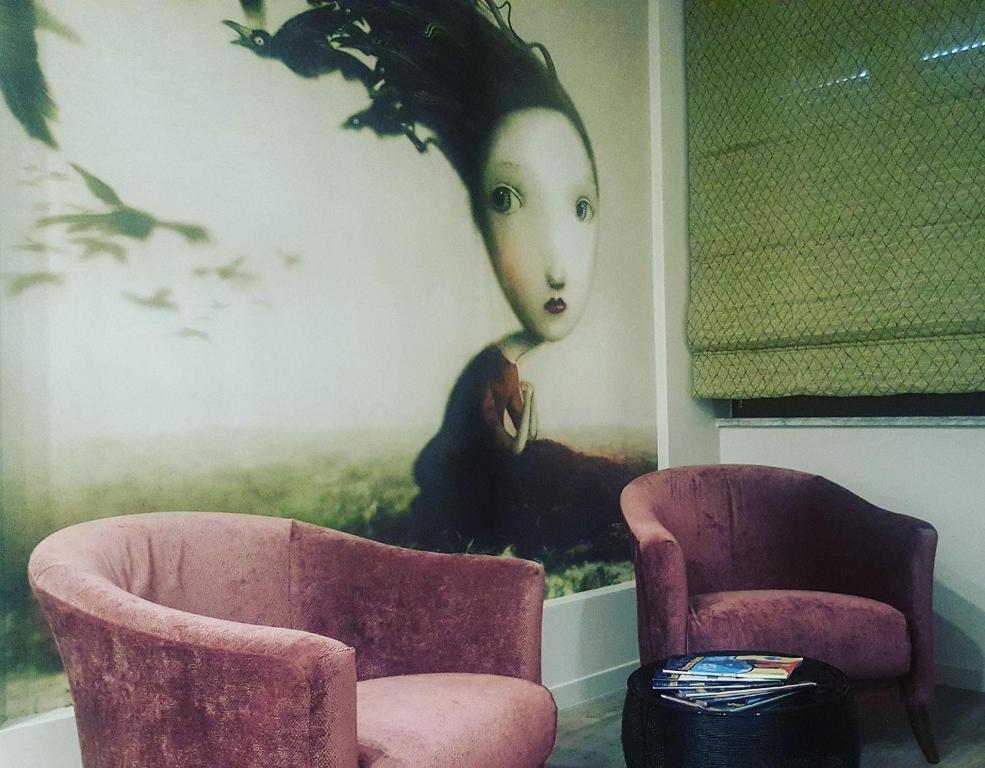 卡西诺B&B Parini的一间房间,配有两把椅子和一幅女画