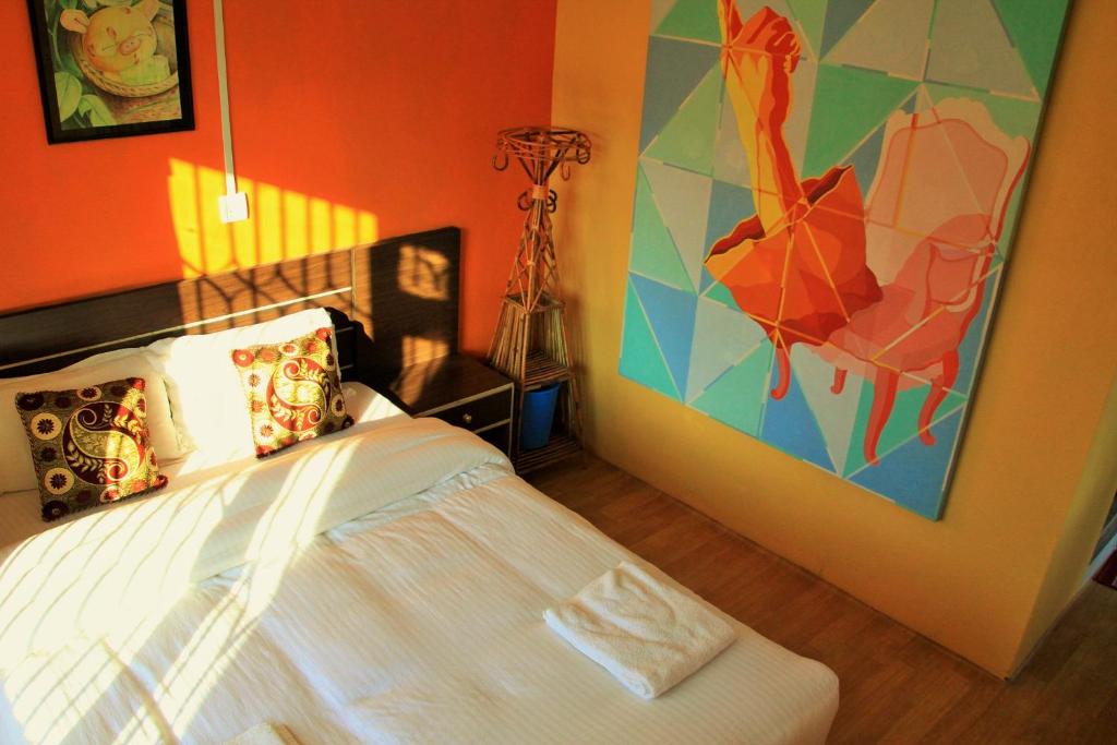 加德满都加德满都村屋酒店的卧室配有一张床,墙上挂有绘画作品