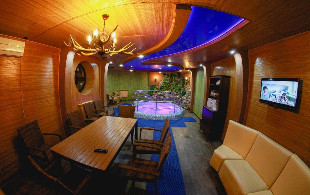 新切尔卡斯克Hotel Nautilus & SPA的一间带桌椅和电视的用餐室