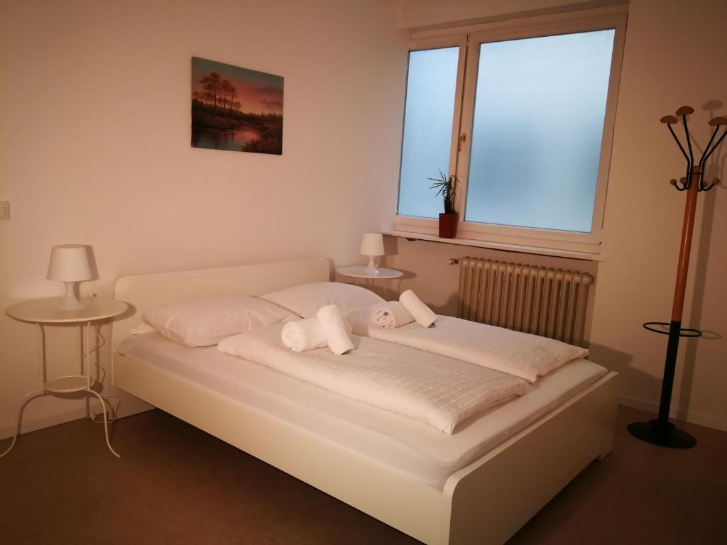 博尔扎诺Central Rooms的一张白色的床,上面有两只填充的动物