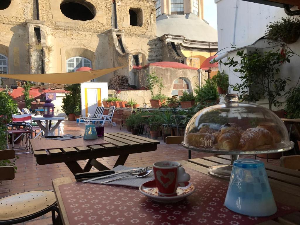 那不勒斯B&B La Terrazza Napoli的一张桌子,上面放着糕点盘和一杯咖啡