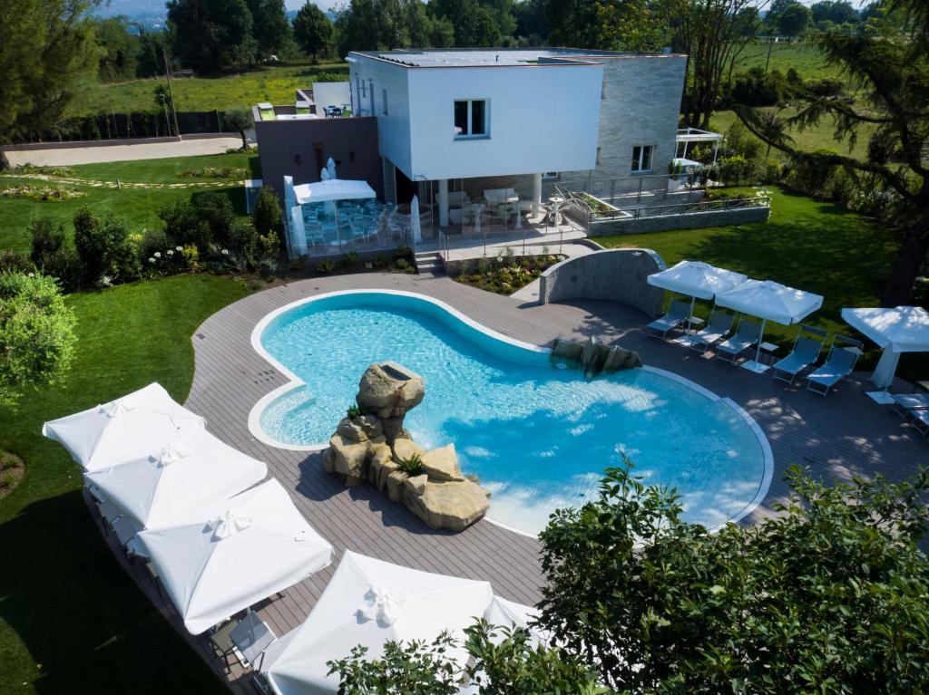 拉齐塞Relais Villa Clodia的享有带遮阳伞和房屋的游泳池的顶部景致