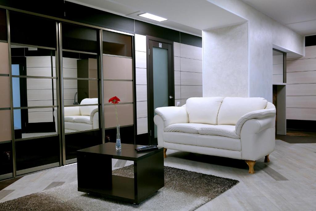 乌拉尔斯克Apartments DAF-Center的客厅配有白色椅子和桌子