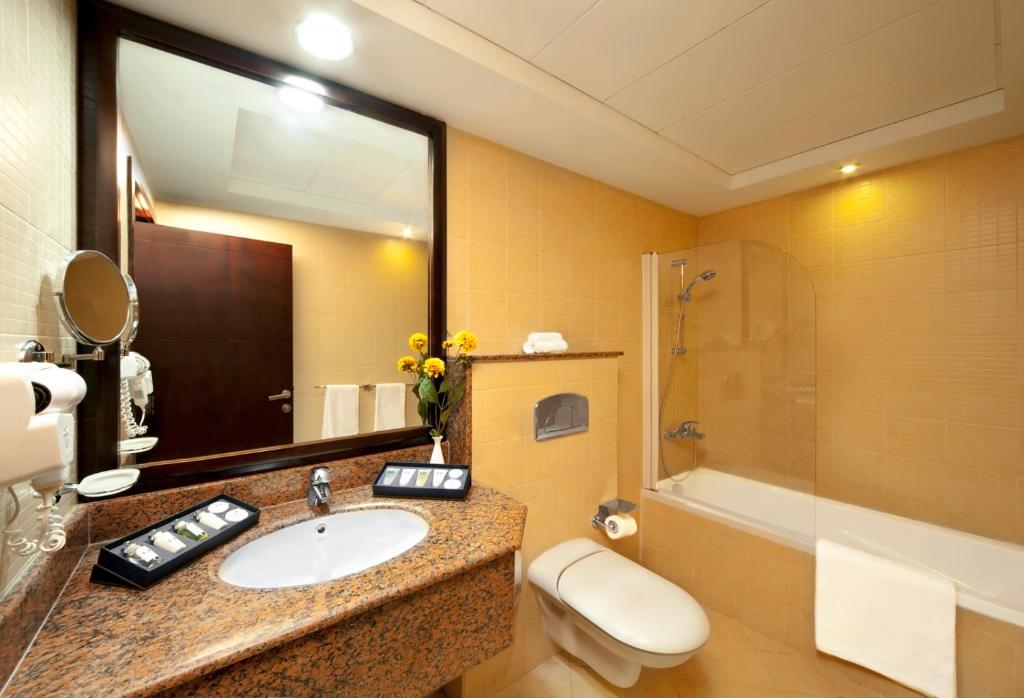 多哈Corp Executive Hotel Doha Suites的一间带水槽、卫生间和淋浴的浴室