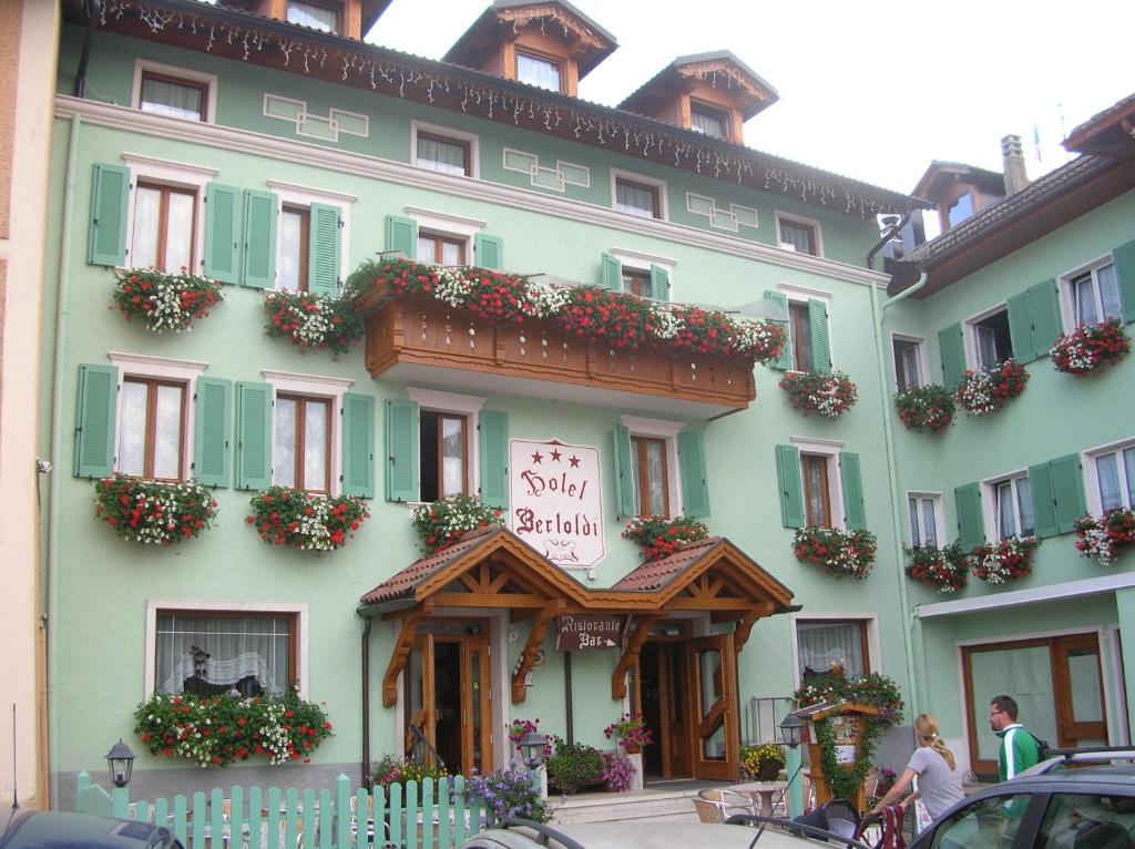 拉瓦罗内贝尔托尔迪酒店的一座绿色的大建筑,上面有标志