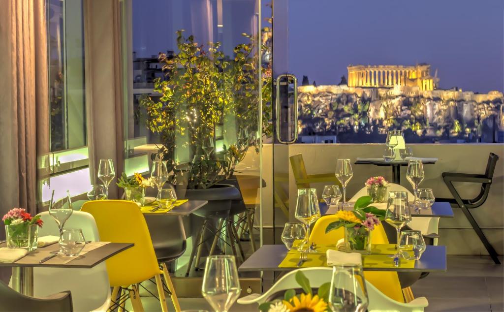 雅典波里斯大酒店的餐厅设有黄色椅子和鲜花
