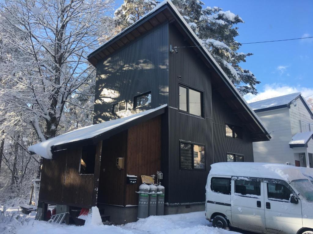 白马村黄色小屋旅馆的一辆停放在雪中的黑色房子