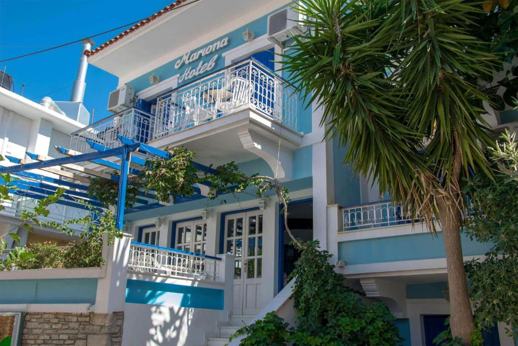 毕达哥利翁Hotel Mariona的蓝白色的建筑,棕榈树