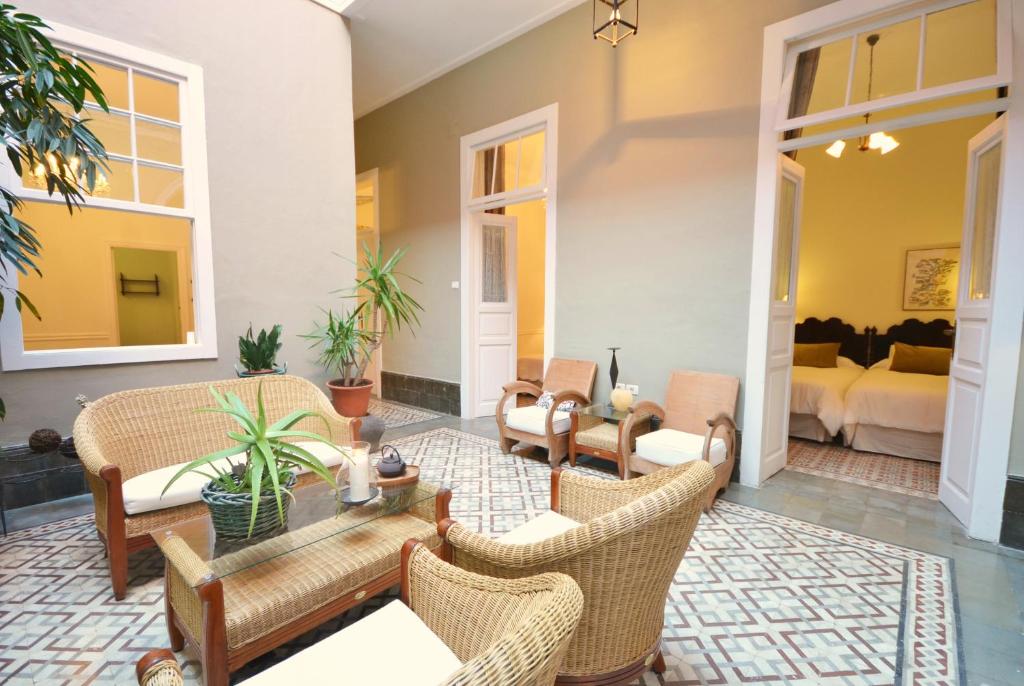 大加那利岛拉斯帕尔马斯卡萨德维古埃塔酒店的客厅配有藤椅和桌子