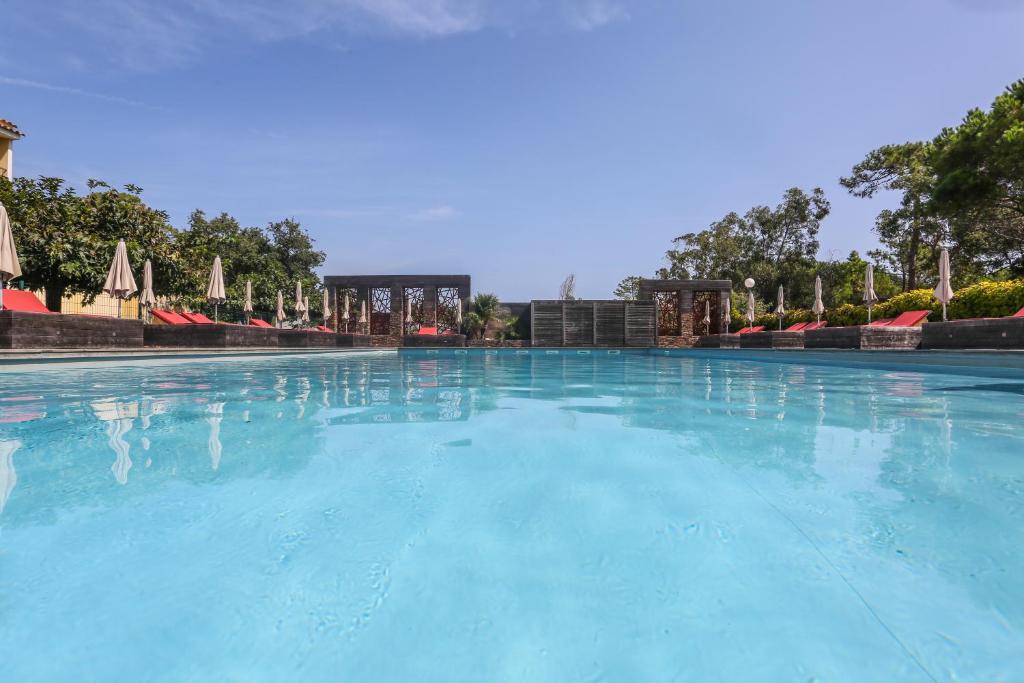 博尔戈伊索拉酒店的一座带蓝色水和遮阳伞的大型游泳池