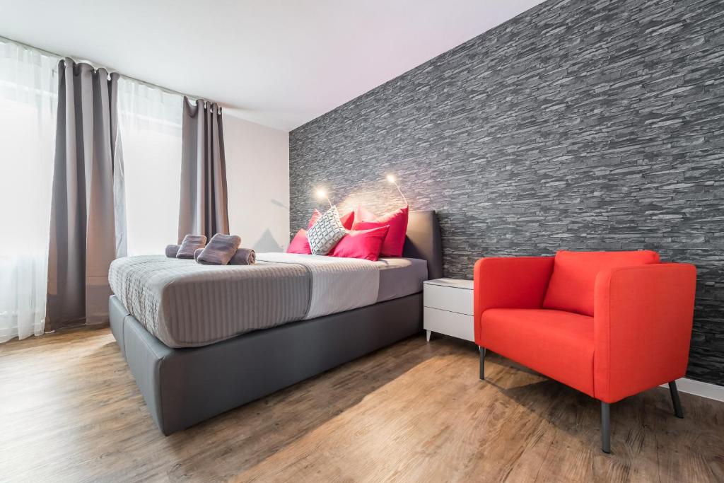 弗莱堡Wohnen auf Zeit - Innenstadt-Appartements的一间卧室配有一张床和一张红色椅子