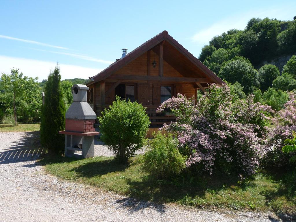 杜谢Chalets les Silènes的一座带烟 ⁇ 和灌木的小木房子
