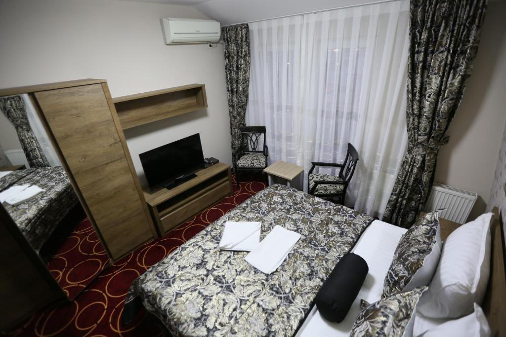 普里什蒂纳Hotel Pejton的酒店客房,配有床和电视
