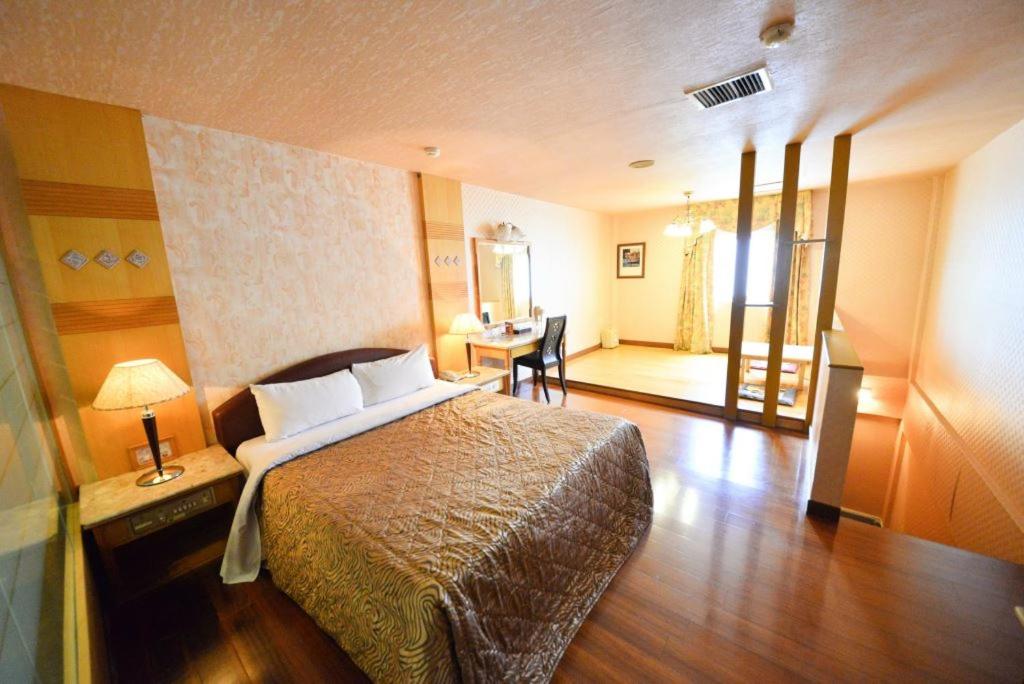 台南百威汽车旅馆的配有一张床和一张书桌的酒店客房