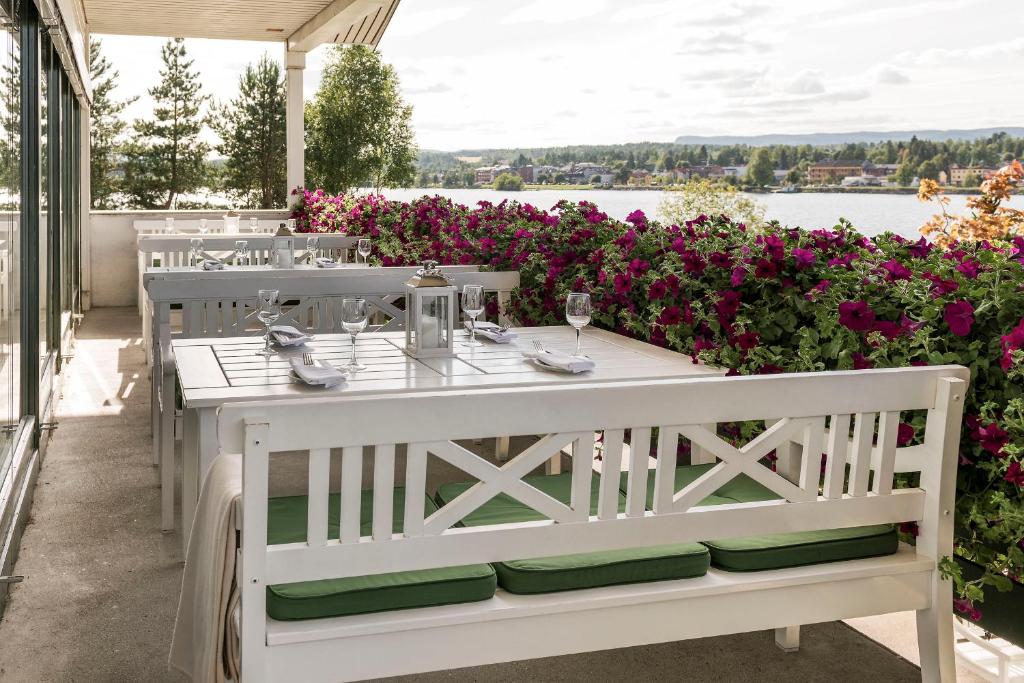 维克松Tyrifjord Hotell的鲜花庭院里的白色桌子和椅子