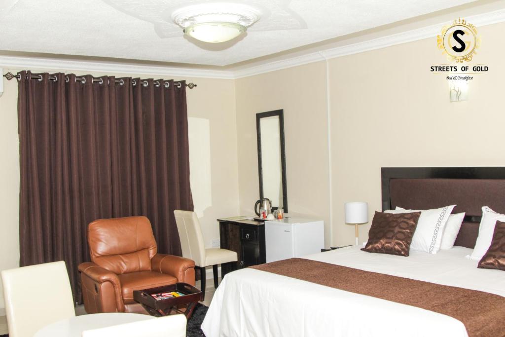 哈博罗内黄金街道旅馆的配有一张床和一把椅子的酒店客房
