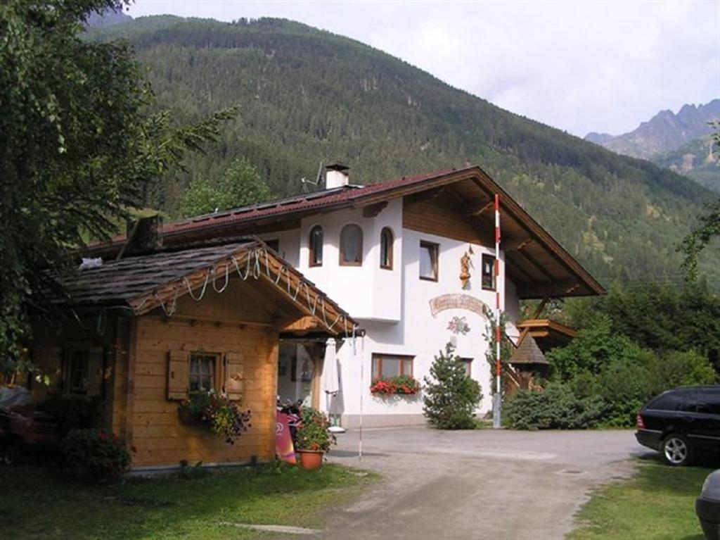 大基希海姆Camping Gasthof Zirknitzer的山间房子,前面有停车位