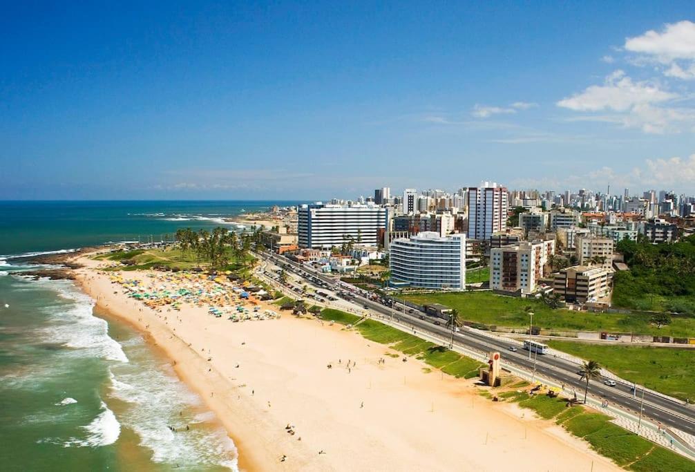 萨尔瓦多Apartamento na praia de Armação的一片有人与海洋的海滩和一个城市