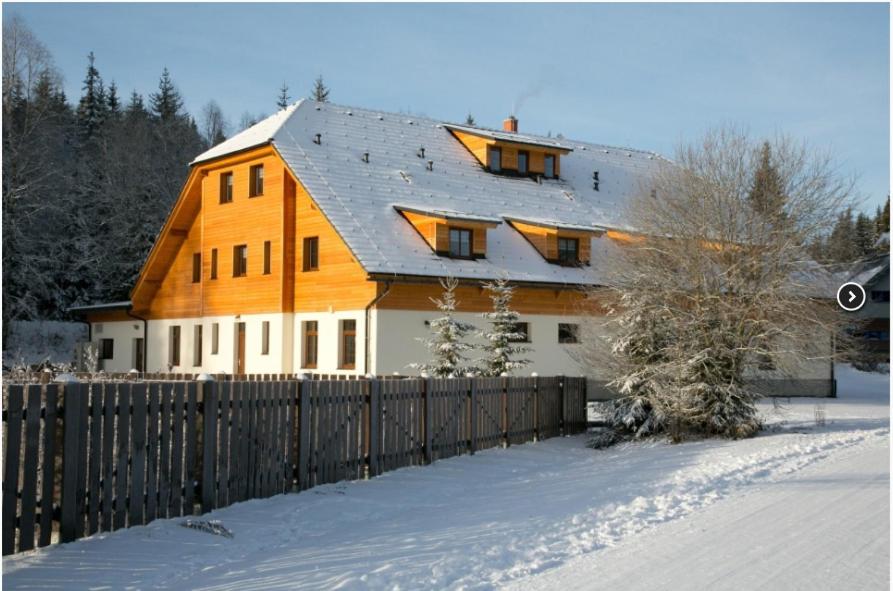 莫德拉瓦Chata u Tří Sluk的一座大木房子,雪中设有围栏