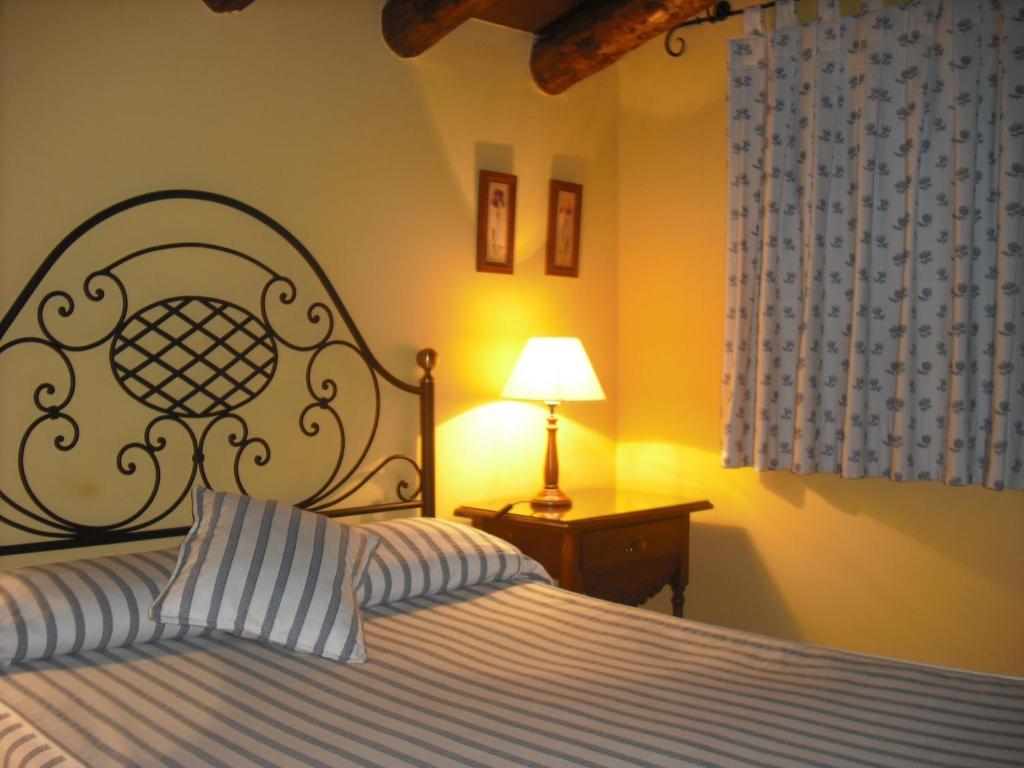 阿尔巴拉辛奥里亚旅馆的一间卧室配有一张床和一张桌子上的台灯