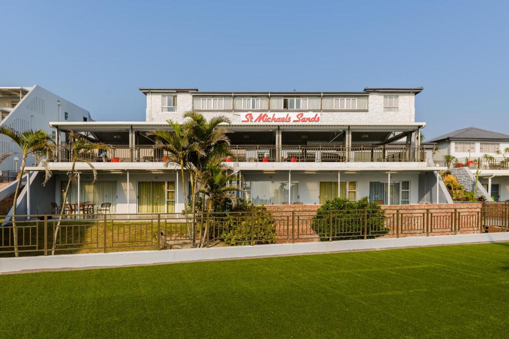 谢丽海滩St Michaels Sands Hotel & Time Share Resort的前面有绿色草坪的建筑