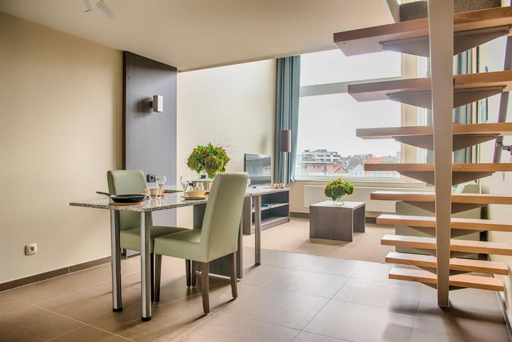 安特卫普Arass Hôtel & Business Flats的一间带桌子和螺旋楼梯的用餐室