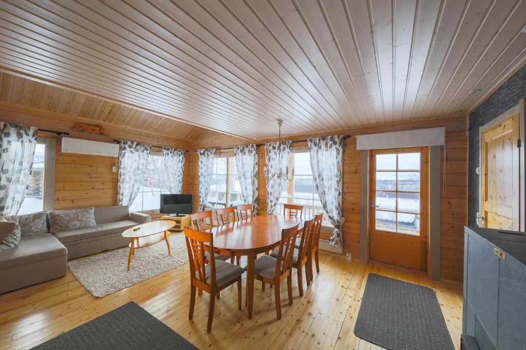 NuorgamArctic Aurora Borealis cottages的客厅配有桌椅和沙发