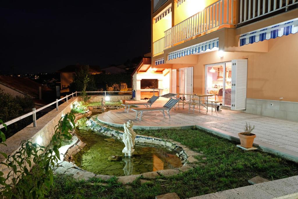 奥库格哥恩基Villa Wind的一座房子,晚上在院子里有一个喷泉