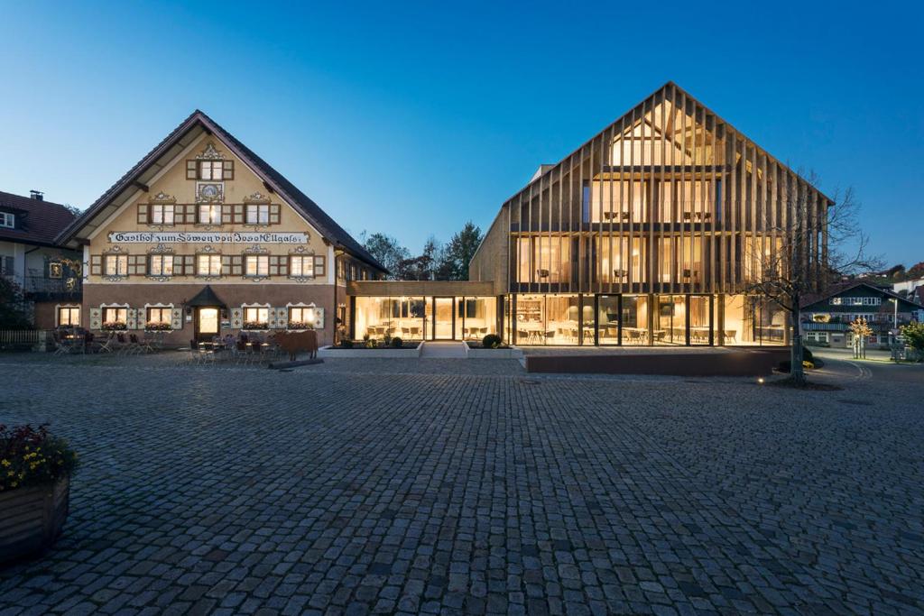 EglofsEllgass Allgäu Hotel的一座带灯的大型木质建筑