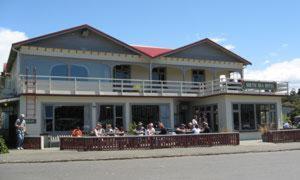 半月湾南海汽车旅馆 - 斯图尔特岛的一座大型建筑,人们坐在阳台上