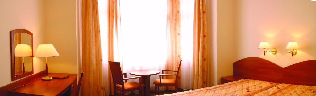 波兹南Nasz Klub - Pokoje Gościnne的一间卧室配有一张床、一张书桌和一面镜子