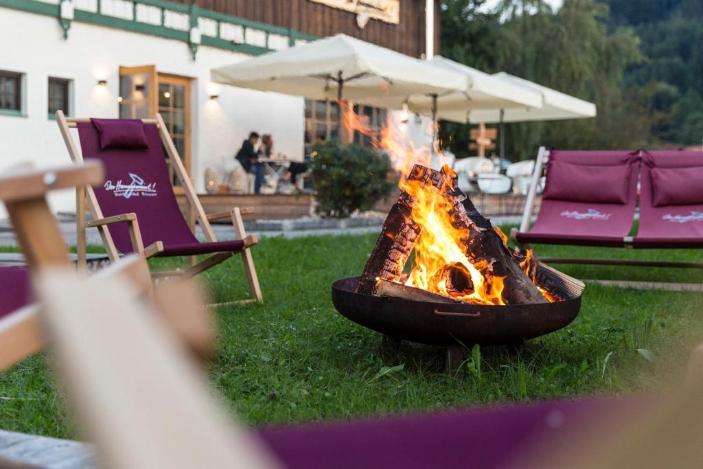 希格斯多夫汉姆维特霍特瑞酒店的草地上的火坑,带椅子和雨伞
